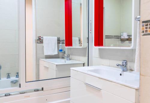 a white bathroom with a sink and a mirror at Apartamento moderno en Tanger in Tangier