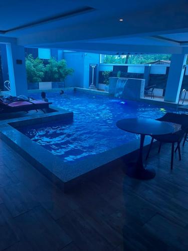 a large swimming pool with a table in the middle at DE-WILLIAMS PLACE hotel in Ibadan