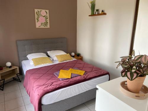 a bedroom with a bed with a purple blanket at La dame du bois in Gramat