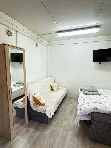 a small room with a bed and a mirror at Domek u Franka in Smołdzino