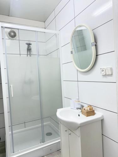 a bathroom with a shower and a sink and a mirror at Domek u Franka in Smołdzino