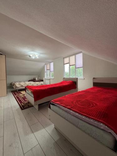 a large bedroom with two beds and two windows at Ademi Guest House in Kochkorka