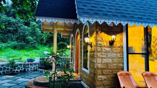 a building with a table and chairs on a patio at StoneHaven 1BHK pvt Pool in Agashi