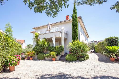a house with plants in front of it at Apartments Villa Mantinela in Malinska