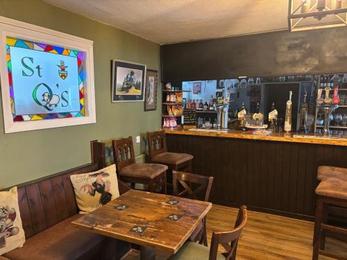 a dining room with a table and a bar at Saint Quintin Arms in Harpham