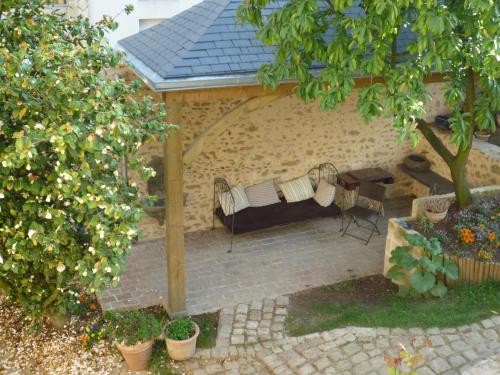 an outdoor patio with a couch and a table at Chambres d'hôtes Le Clos d'Hauteville in Le Mans
