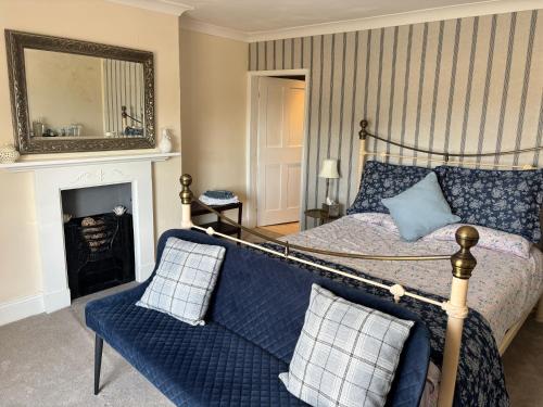 a bedroom with a bed and a couch and a mirror at Saint Quintin Arms in Harpham