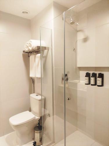 ein Badezimmer mit Toilette und Glasdusche in der Unterkunft Holanda Gold Hotel Praia de Tambaú in João Pessoa