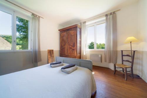 a bedroom with a large white bed and windows at Chez Sylvain in Issor