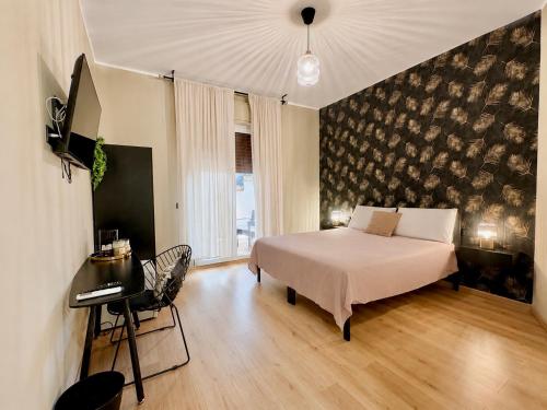a bedroom with a bed and a desk and a piano at Favola Guesthouse Affittacamere in Nettuno