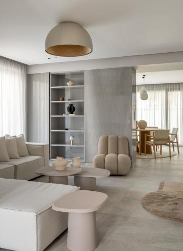 a living room with white furniture and a table at Villa Occasus by A&D Properties in Porto Rafti