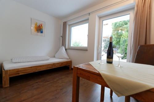 a room with a bed and a table with a bottle of wine at Pension Christina in Vaihingen an der Enz