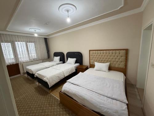 a room with two beds and two windows at Kır Home in Çaykara