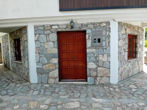 a red door on the side of a stone building at Villa Galicnik in Galičnik