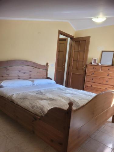 a bedroom with a large wooden bed and a dresser at I 23 PASSI Alfedena in Alfedena