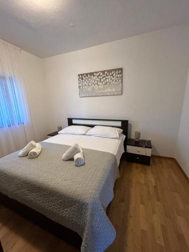 a bedroom with a bed with two towels on it at Apartment Roko (10m from the beach) in Pašman