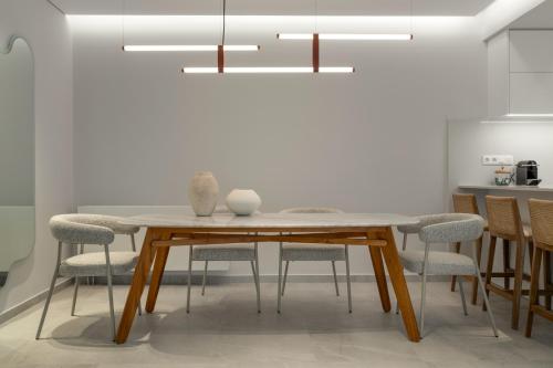 a dining room with a wooden table and chairs at Villa Occasus by A&D Properties in Porto Rafti