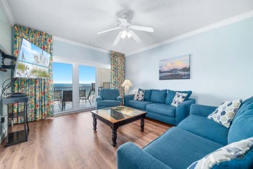 a living room with a blue couch and a table at Dolphin Key 3C in Orange Beach