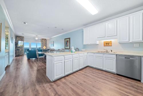 a kitchen with white cabinets and a dining room at Dolphin Key 3C in Orange Beach