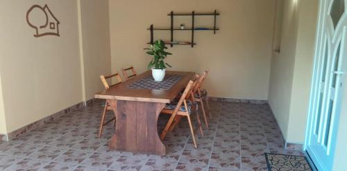 a dining room table with a potted plant on it at Zöld Udvar Pihenőház in Jászszentlászló