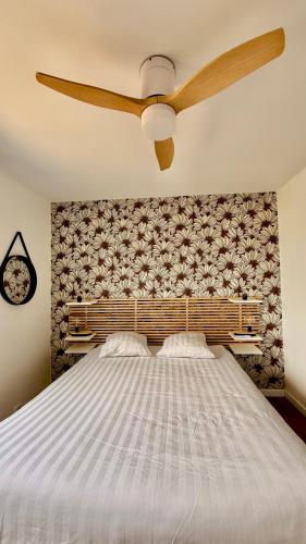 a bedroom with a large bed with a ceiling fan at Hyper Centre - Draps Inclus - Fibré - Parking - Local Vélos - Jusqu'à 6 personnes in Saint-Brevin-les-Pins