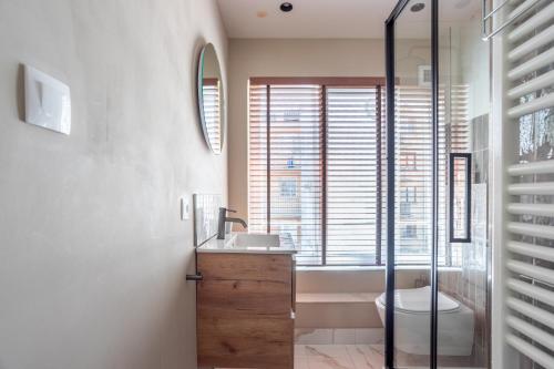 a bathroom with a sink and a tub and a toilet at Luxury Apartment Knokke-Heist in Knokke-Heist