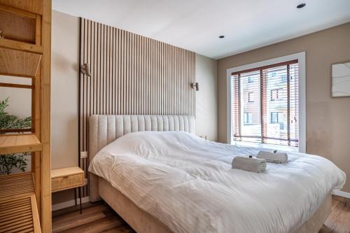 a bedroom with a white bed and a window at Luxury Apartment Knokke-Heist in Knokke-Heist