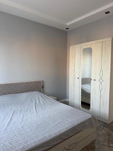 a bedroom with a bed and a mirror at Sunset Garden Apartment 3 in Bilgah