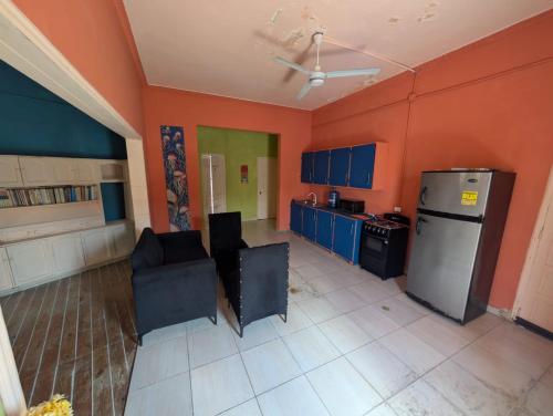 a kitchen with orange walls and a refrigerator and chairs at El europeo in Santo Domingo