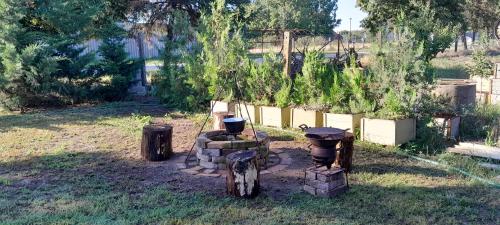 a garden with a fire pit in the grass at Zöld Udvar Pihenőház in Jászszentlászló