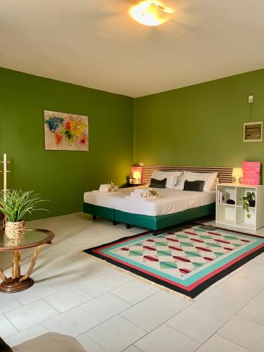 a bedroom with a bed and a green wall at Bnbook Villa Biancospino in Travedona