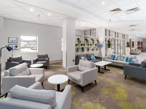 a waiting room with couches and chairs and tables at Novotel Southampton in Southampton