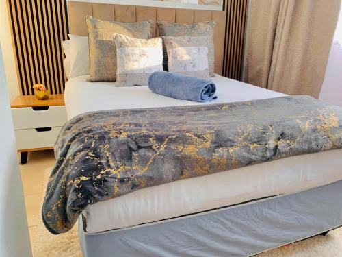 a bed with a blanket on top of it at Asanta Guest House in Ladysmith