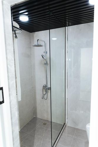 a shower with a glass door in a bathroom at Leore Hotel in Namangan