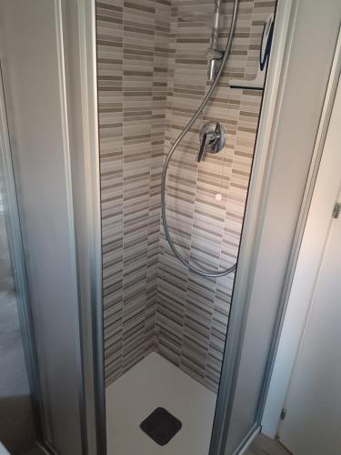 a shower with a hose in a bathroom at La Maison de Roland in Pescara