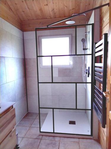 a shower with a glass door in a bathroom at Chalet Chez Jeannot, N6 in Mauroux