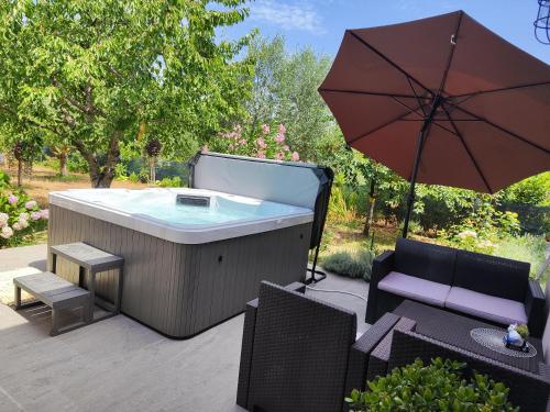 a hot tub with an umbrella on a patio at Rooms Katarina in Poreč
