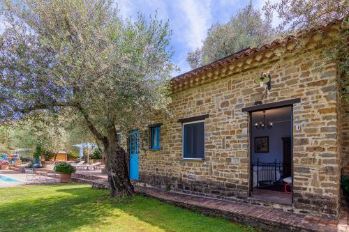 a brick house with a tree in the yard at Agriturismo Il Vecchio Casale in Vatolla