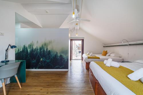 a bedroom with two beds and a large painting on the wall at BeSmart Suites with Private WC by Home Sweet Home Aveiro in Aveiro
