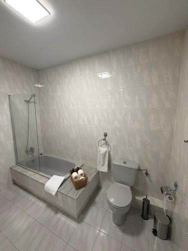 a bathroom with a tub and a toilet and a sink at A Casa do Miradoiro in Puentedeume