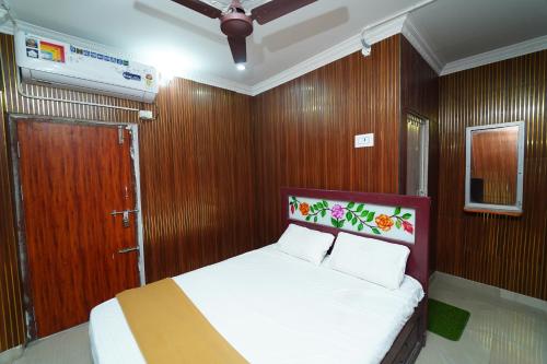 a bedroom with a bed with wood paneling and a door at Udhaya Lodge in Rāmeswaram