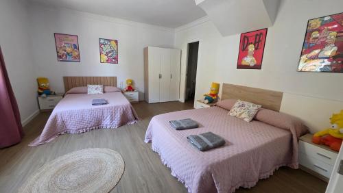 a bedroom with two beds with pink sheets at The Simpsons in Seville in Mairena del Aljarafe