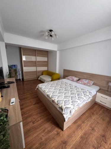 a bedroom with a large bed and a desk at Brown Aparts in Chişinău