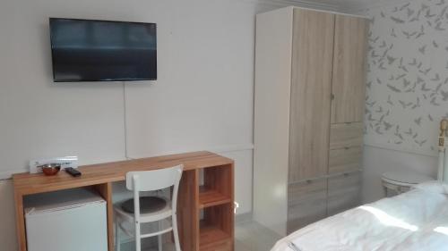 a bedroom with a desk and a tv on a wall at Royaltybed Copenhagen in Copenhagen