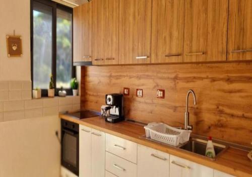 a kitchen with wooden cabinets and a sink at Casa in Durrës