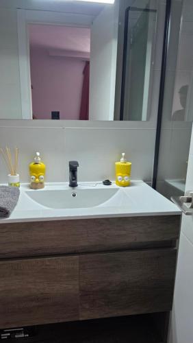 a bathroom with a white sink and a mirror at The Simpsons in Seville in Mairena del Aljarafe