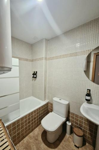 a bathroom with a toilet and a tub and a sink at Casa Ariño Ruidera in Ruidera