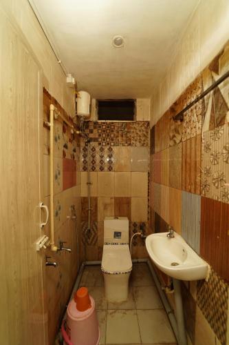 a small bathroom with a toilet and a sink at Udhaya Lodge in Rāmeswaram