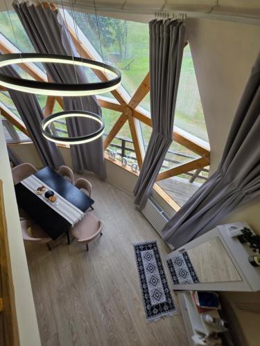 a room with a chair and a large window at Dom Vladeasa in Rogojel