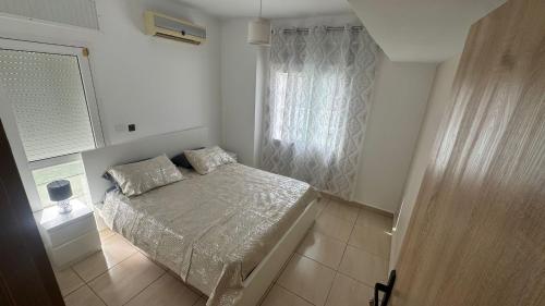 a small bedroom with a bed and a window at Spacious villa, sea view in Cabo Negro